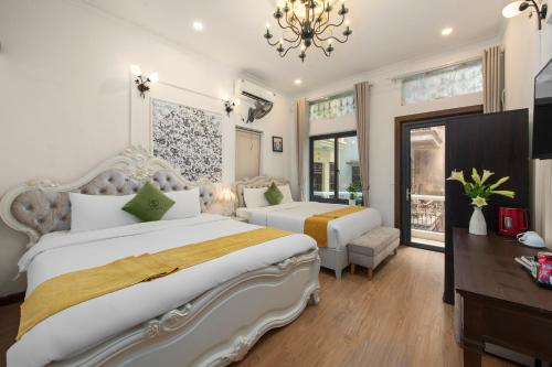 a hotel room with two beds and a chandelier at Hanoi Family Homestay in Hanoi