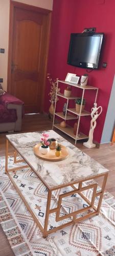 a living room with a coffee table and a tv at Red Apartamento in Asilah