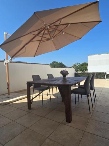 a table with chairs and an umbrella on a patio at La Villa di Alice in Vignacastrisi