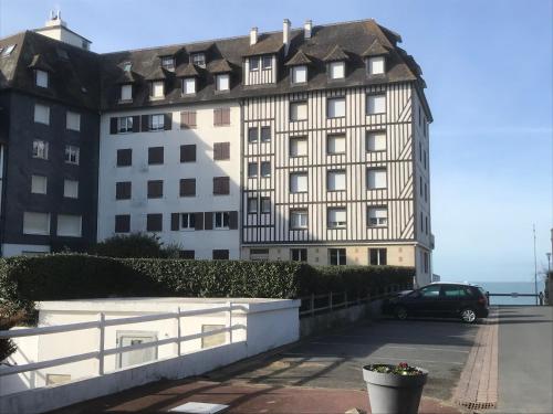 une voiture garée devant un grand bâtiment dans l'établissement Appartement 2 pièces sur plage, à Blonville-sur-Mer