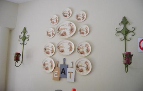 a wall with plates on a white wall at Tengo guest house in Phalaborwa