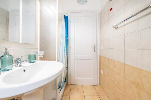 a bathroom with a white sink and a shower at AffittaSardegna - Domo Pineta in Santa Lucia