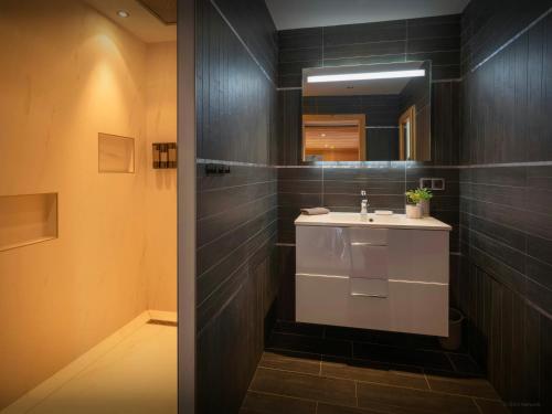 a bathroom with a sink and a mirror at Chalet Wanderlust - OVO Network in Châtel