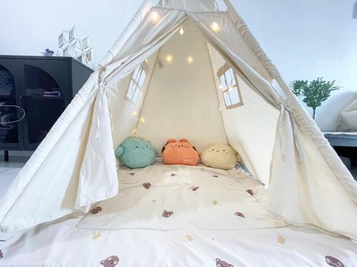 ein Bett mit drei Stofftieren in einem Zelt in der Unterkunft Next to Paradigm Mall Escape JB,3BR, Up to 10 Person, in Johor Bahru