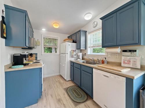 a kitchen with blue cabinets and a white refrigerator at Sweet Beach Retreat home in Wells