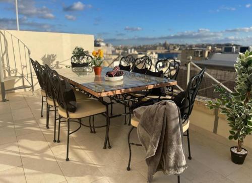 a table and chairs on a balcony with a view at Sliema Cozy Townhouse with Rooftop View, Prime Spot in Sliema