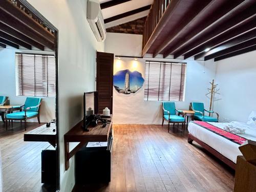 a bedroom with a bed and a desk and chairs at 26 Rangoon Residence 26 in George Town