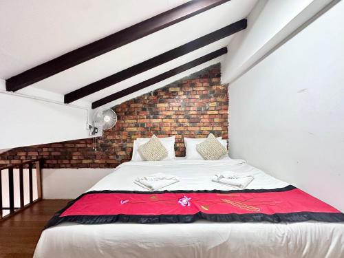 a bed in a room with a brick wall at 26 Rangoon Residence 26 in George Town