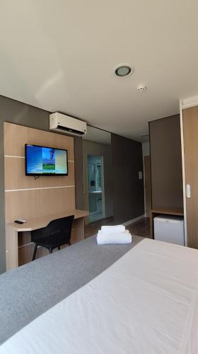 a hotel room with a bed and a flat screen tv at Assay Plaza Hotel in Hortolândia