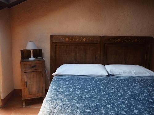 a bedroom with a bed with a wooden headboard and a lamp at Agriturismo La Costa - Casa Vacanze in Perego