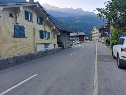 an empty street in a small town with a building at Alpenzauber Chalet 1 - 6 Personen I Bergblick, Nahe Braunwald - Badewanne, nahe Bahnhof und Parkplatz in Diesbach