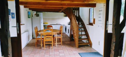 une cuisine avec une table et des chaises ainsi qu'un escalier dans l'établissement Bienvenue à la maison, à Le Theil-en-Auge