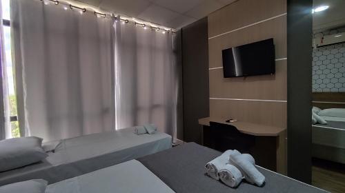 a hotel room with two beds and a television at Assay Plaza Hotel in Hortolândia
