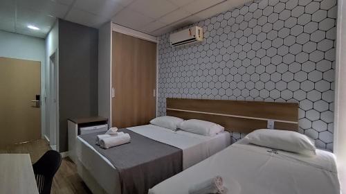 a hotel room with two beds and a mirror at Assay Plaza Hotel in Hortolândia