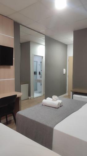 a hotel room with two beds and a mirror at Assay Plaza Hotel in Hortolândia