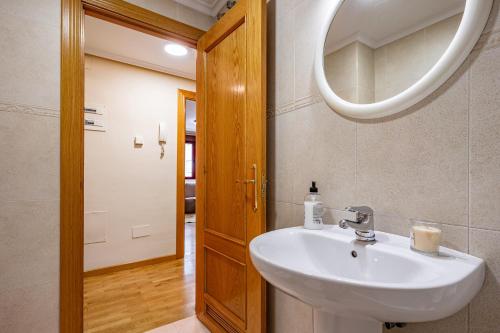 ein Badezimmer mit Waschbecken und Spiegel in der Unterkunft Apartamento Avenida del Mar in Oviedo