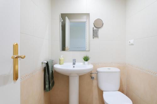 une salle de bains blanche avec toilettes et lavabo dans l'établissement Las Lomas de Bonalba, à Mutxamel