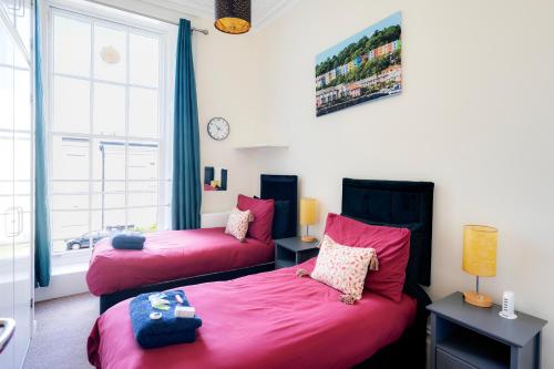 a bedroom with two beds and a window at STR8BS8 Georgian 2-Bedroom Apartment, Clifton, Parking & Garden in Bristol