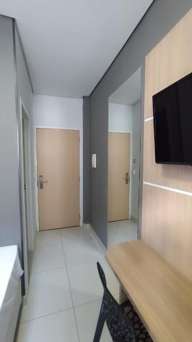 a room with two doors and a tv on a wall at Assay Plaza Hotel in Hortolândia