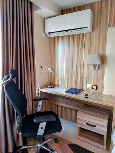 a office with a desk and a chair in a room at Golden Tulip Hotel Port Harcourt -GTPH in Port Harcourt