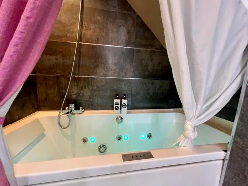 a bath tub with two faucets in a bathroom at Autentico lujo, Villa Stylish Host Cantabria. in Camargo