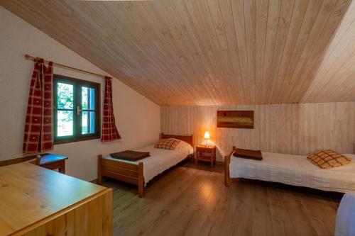 une chambre avec deux lits et un plafond en bois dans l'établissement Gite le Cellier, à Gavaudun