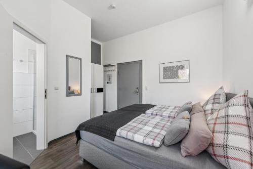 a bedroom with a bed with pillows on it at Diepholzer Boardinghouse by BohnApartments - Parkplätze - WLAN - Garten - ruhig in Diepholz