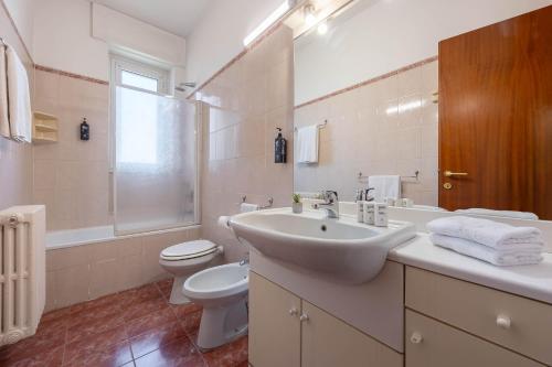 a white bathroom with a sink and a toilet at iH Hotels Milano ApartHotel Argonne Park in Milan