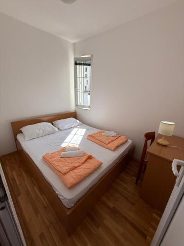 ein Schlafzimmer mit einem Bett, auf dem zwei Handtücher liegen in der Unterkunft Jadran Rafailovic in Rafailovici
