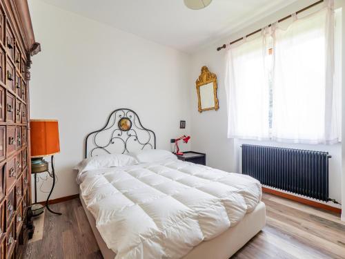 a bedroom with a large white bed and a window at Casa Nina - Wi-fi gratuito in Ballabio