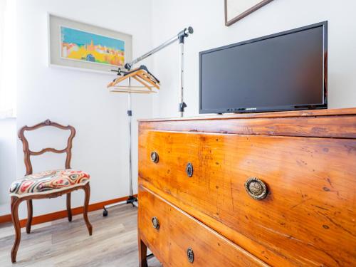 a tv on top of a dresser with a chair at Casa Nina - Wi-fi gratuito in Ballabio