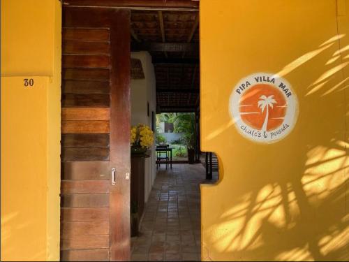 a door to a building with a sign on the wall at Pipa Villa Mar in Pipa