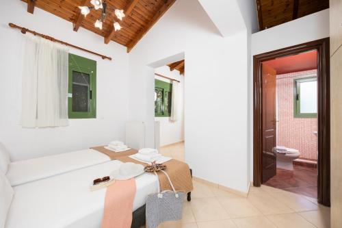 a white room with a bed and a toilet at Villa Poseidonia in Katelios