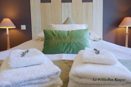 a bedroom with a bed with white towels on it at La Villa Des Raspes - Séjour Spa - Adult Only in Viala-du-Tarn