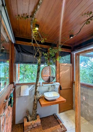 a bathroom with a tree in the middle of it at Trance rabara resort in Avissawella