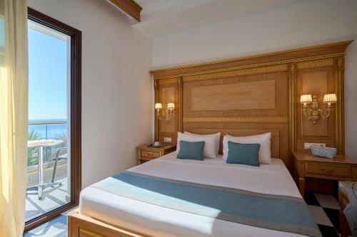 a bedroom with a large bed with a large window at EVLOGIA HOTEL SEAFRONT and ANEX by Greek Pride in Fourka