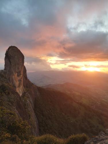 a view of a mountain with the sunset in the background at Chalé Refugio da Pedra SP in São Bento do Sapucaí