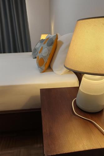 a bed with a pillow on it next to a lamp at Casa TIANA in Mindelo
