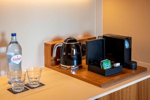 a hotel room counter with a coffee maker and a bottle of water at 3HB Falesia Beach in Albufeira