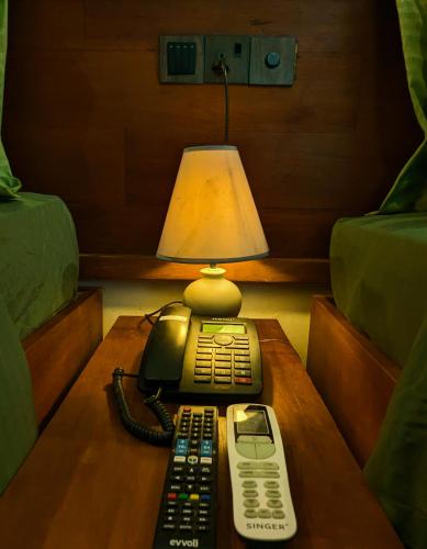 a telephone and a cell phone on a table at Trance rabara resort in Avissawella