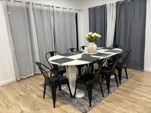 a black and white table with chairs and a vase of flowers at Urban Pause - Doreen in Doreen