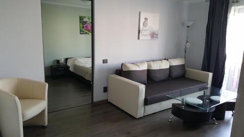 a living room with a couch and a mirror at L.E.C. Travel Apartments Ventspils in Ventspils