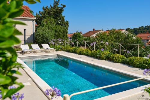 a swimming pool with two lounge chairs next to a house at Hedera Estate Villa Hedera XVIII in Mlini