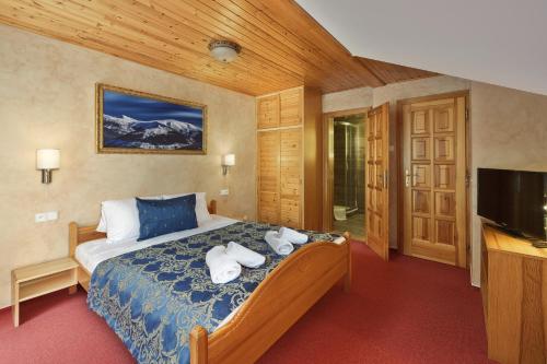 a bedroom with a bed with towels on it at Hotel Resort Martin & Kristyna in Špindlerův Mlýn