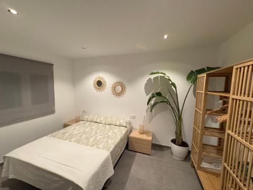 Un dormitorio con una cama y una planta en maceta. en Villa Oasis, en Albacete