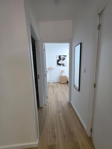 an empty hallway with white walls and wood floors at Casa de ferias escapadas casa amorosa Tranquilidade e natureza 2 quartos 6 pessoas in Loulé