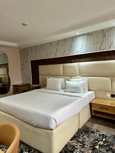 a bedroom with a large bed with white sheets at Golden Tulip Hotel Port Harcourt -GTPH in Port Harcourt