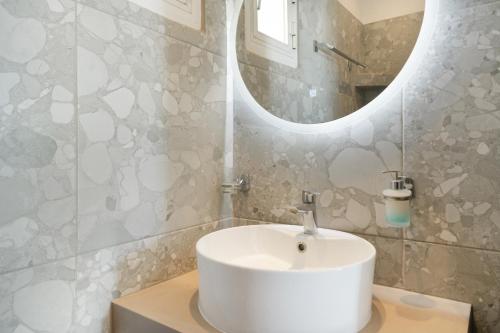 a bathroom with a white sink and a mirror at Country House Apartments in Ios Chora