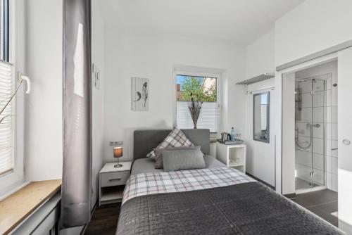 a small bedroom with a bed and a shower at Diepholzer Boardinghouse by BohnApartments - Parkplätze - WLAN - Garten - ruhig in Diepholz