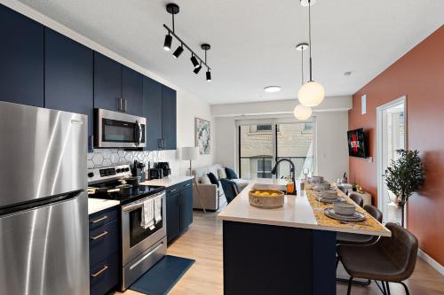 a kitchen with blue cabinets and a stainless steel refrigerator at W318 Chic & Luxury 1Bd Condo In Downtown Minneapolis, Minutes From Minneapolis Convention Center & US Bank Arena in Minneapolis